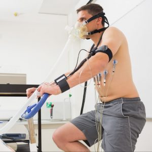 A man on a stationary bike participates in a stress test. 