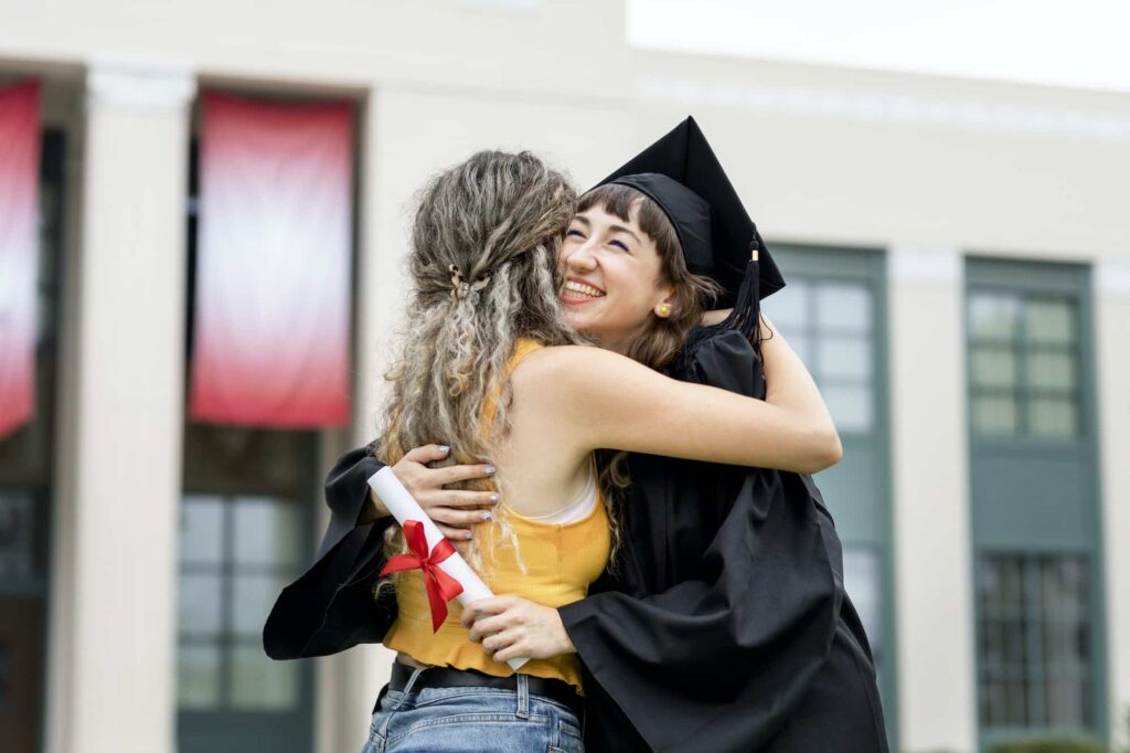 friends hugging at graduation ceremony