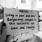 Ali is holding a sign that reads: “ME/CFS is living in pain and fear. Bargaining, frozen in the outskirts of time and reality.”