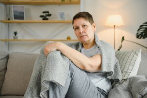 Women with ME/CFS sitting on couch struggling with chronic fatigue symptoms