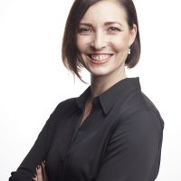 The image features Michelle James, PhD, who is smiling. She has short, dark hair and is wearing a black collared shirt.