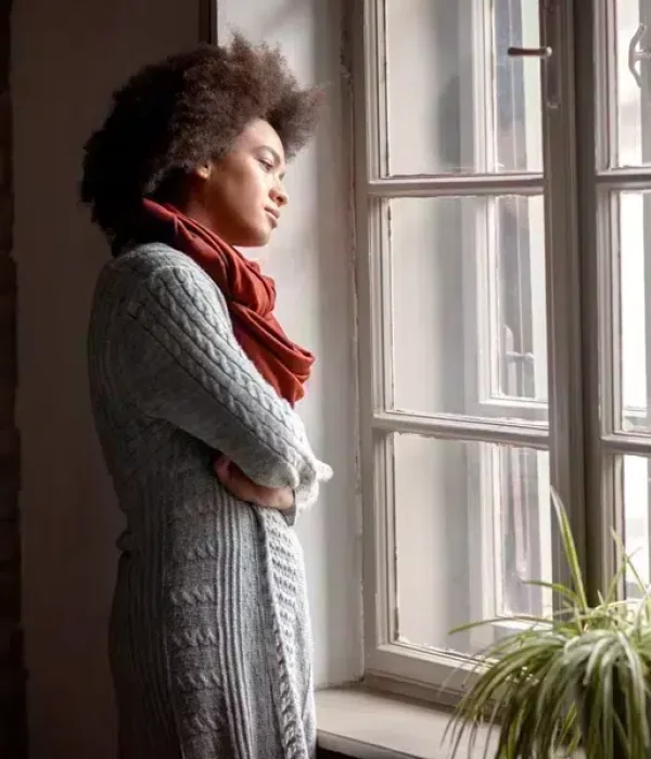 Woman sadly standing at window