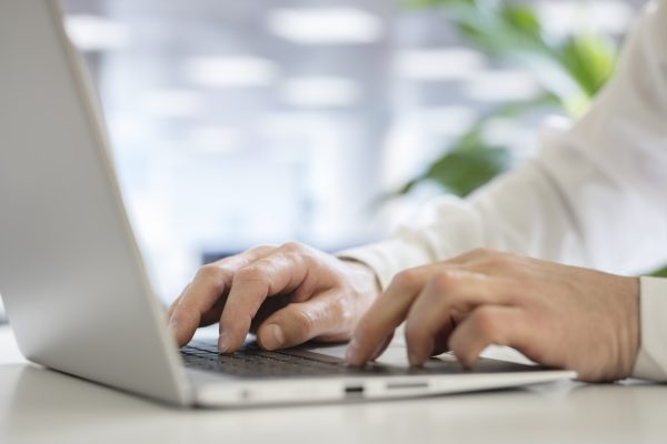 Hands typing on laptop computer